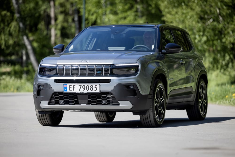 Grå Jeep Avenger foran grønne busker